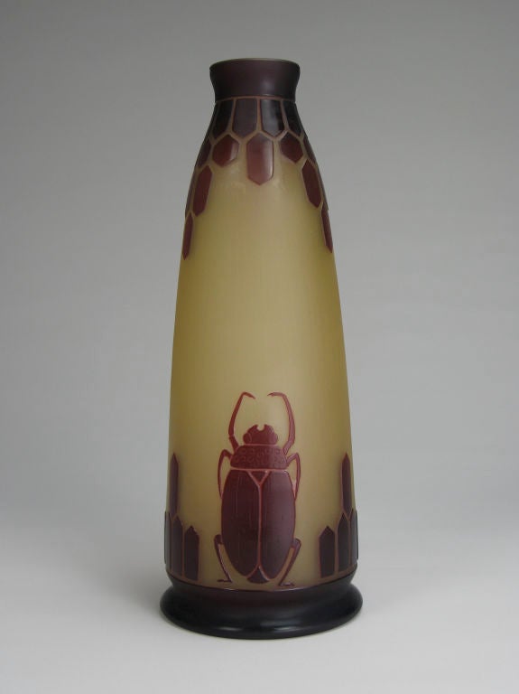 Of slender tapering form with burgundy lozenge frieze and scarab beetles on an amber ground. <br />
<br />
Le Verre Francais is a type of cameo glass made by the Schneider Glassworks in France. The glass was made by the C. Schneider factory in
