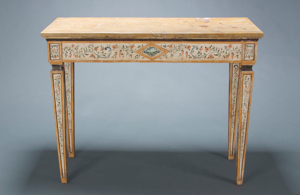 The tables are painted with scrolling flowering vines, each side centered by lozenges depicting a pastoral landscape. The four square legs are paneled and tapered. The molded-edge rectangular tops are a lovely, warm-toned Siena marble.