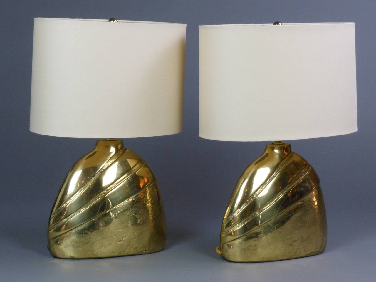 The sculptural bell form lamps incised with diagonal lines. Each lamp is signed on the side. See signature detail in the photos.

Dimensions: Height to light fitting: 10