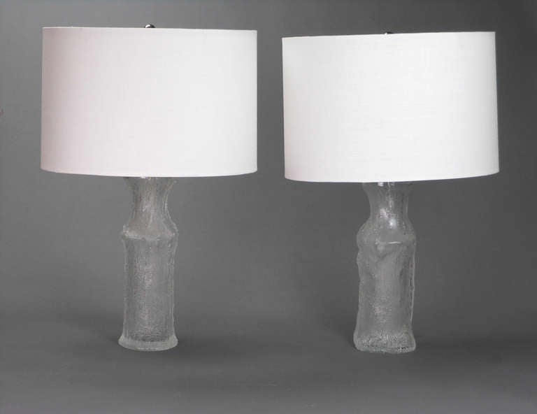 The Swedish cast glass lamps are in the form of tree trunks.

Timo Sarpaneva (1926-2006) was an influential Finnish designer, sculptor, and educator best known in the art world for innovative work in glass. His designs for Iitala won numerous