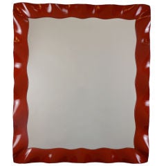 A French Red Lacquer Wave Molded Mirror