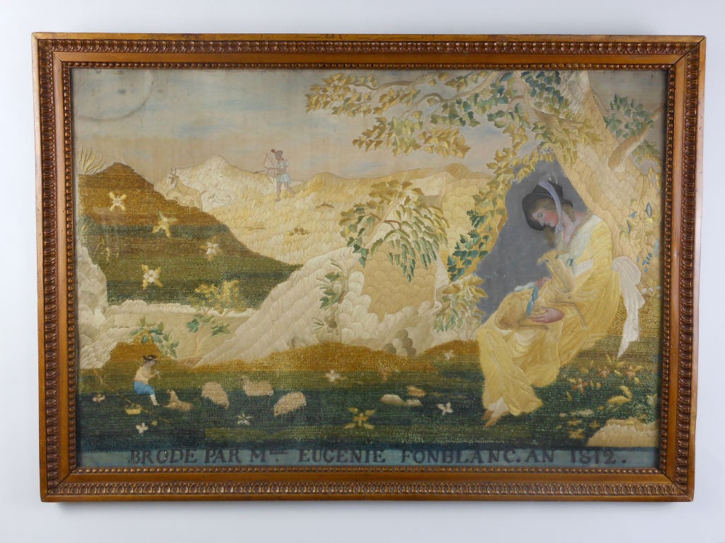 This embroidery portrays a lady seated under a tree with a lamb on her lap in the foreground, a shepherd with his flock in the mid-range, and mountains in the distance. 

Signed "Brodé Par Mlle Eugenie Fonblanc. An 1812."