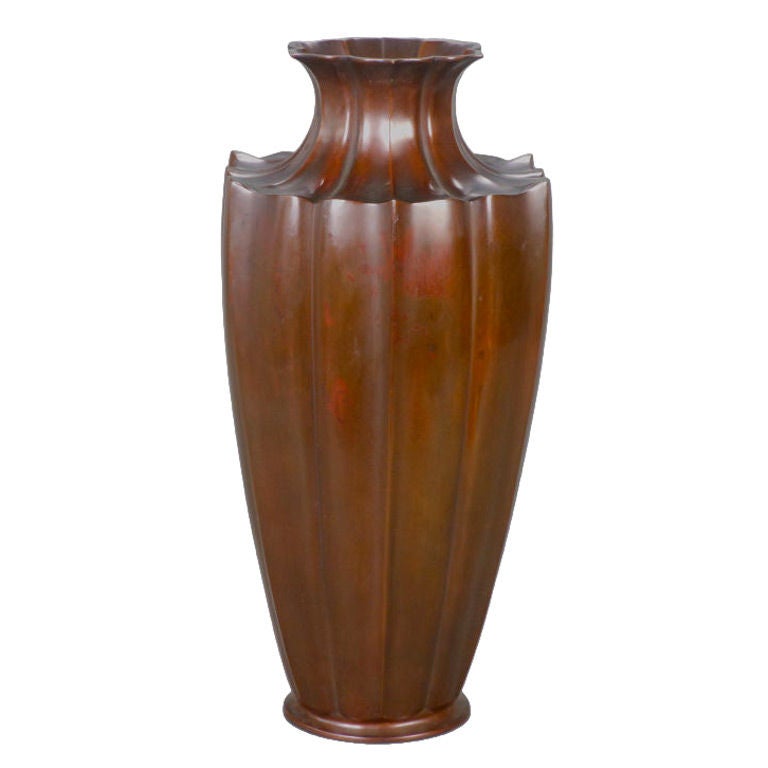 This tall, striking Japanese vase opens above a hexagonal, lotus form lobed neck and conforming tapering body. With red and brown patination.