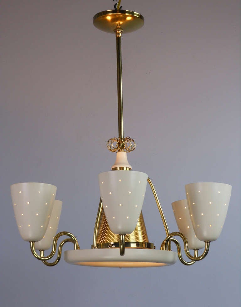 The circular domed corona above the perforated cone encircled by a dish fitted with six s-form arms supporting pierced cup shades.