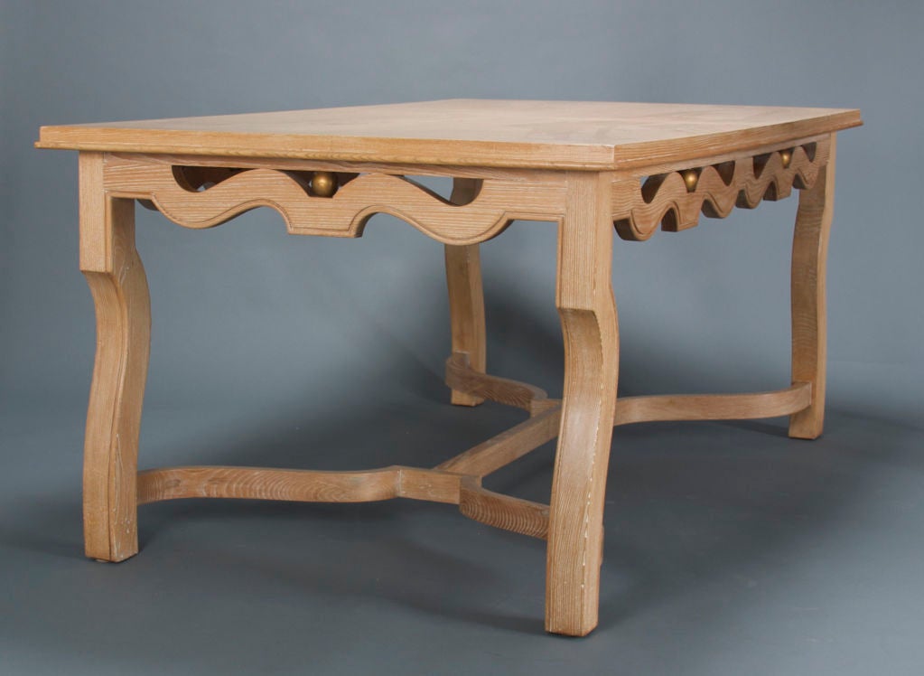 The rectangular molded edge bookmatched parquetry top above the open undulating apron with gilded spheres, raised on reverse cabriole legs joined by a scrolling H-shape stretcher.