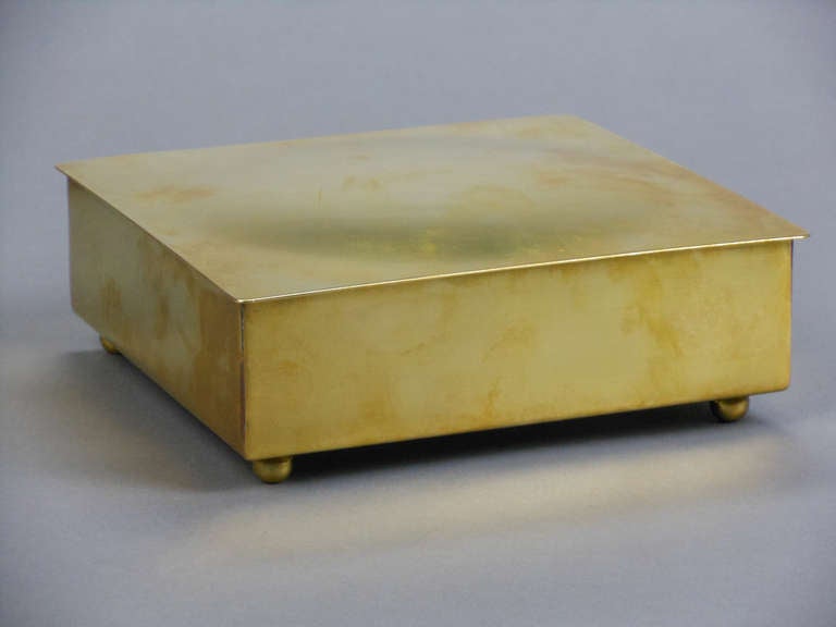 The hinged square cover opens to a wood lined interior, with ball feet. Stamped with a turret on lid and with Elite Brass Works Camirand Limited Montreal Canada. 
J.D. Camirand & Company produced quality brass and silver plate ware in Montreal