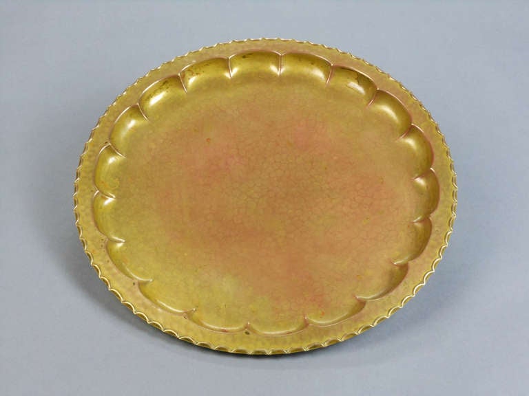 This circular scalloped-edge dish has a lobed interior and a beautiful patina. Stamped with artist's stork monogram and Eingtr. Schutzm. Ges. Gesch. (registered trademark, protected by law).

Ignatius Taschner (b. Bad Kissingen, 9 April 1871; d.