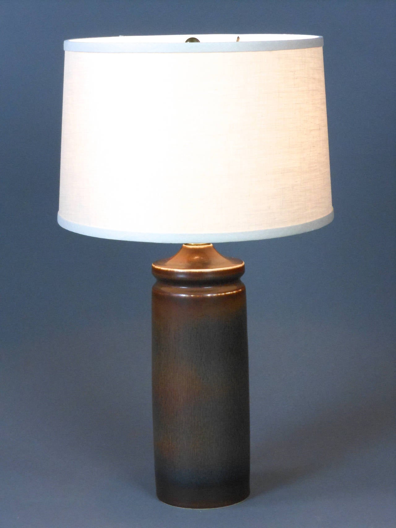The Swedish modern column-shaped brown earthenware lamp has a domed, banded capital. The lamp is marked on the bottom with the Rörstrand cipher (R with three crowns) and CHS Sweden 241.

Measures: Height to light fitting 12 inches
Height to top of