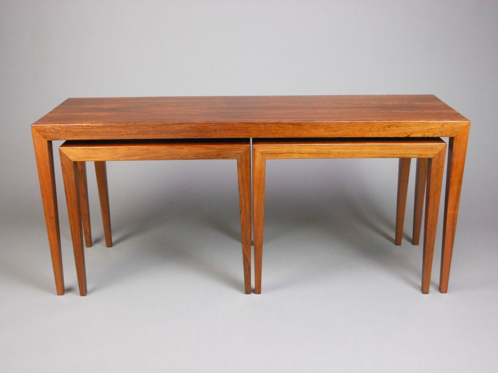 Of rectangular form on square tapering legs, with two conforming nested tables.