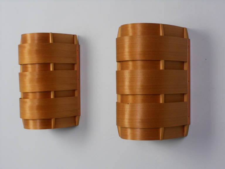 Each Swedish wooden sconce of curved form with alternating bands.

Hans-Agne Jakobsson (1919-2009) began his career as an Industrial designer for General Motors, but changed direction once he became assistant to the prominent furniture designers