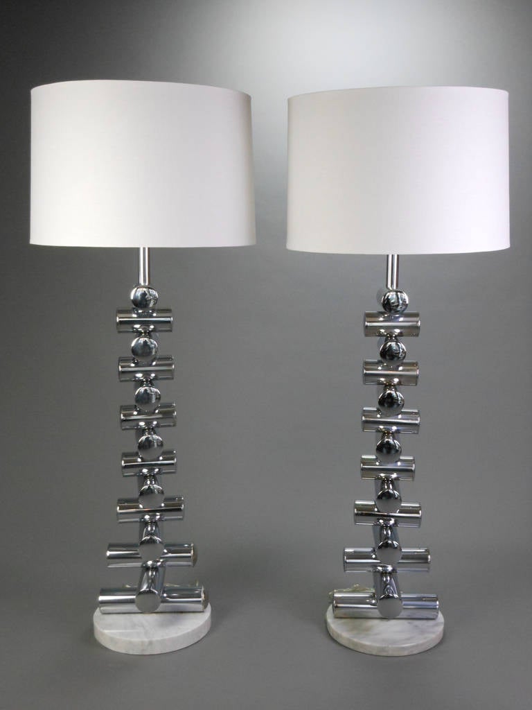 The matched pair of Italian steel and marble floor lamps are composed of steel stacked cylinders on a circular marble base. These can also work as large table lamps.