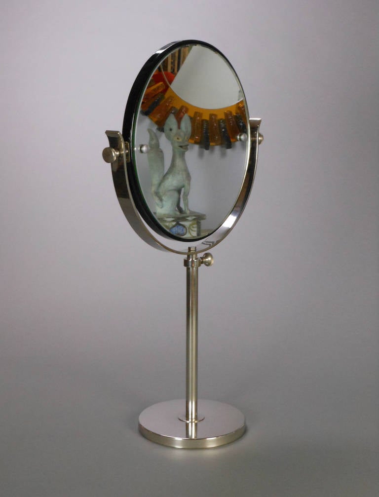 The Swedish Grace period table mirror is comprised of a tilting round mirror mounted in a U-form support on a circular base.