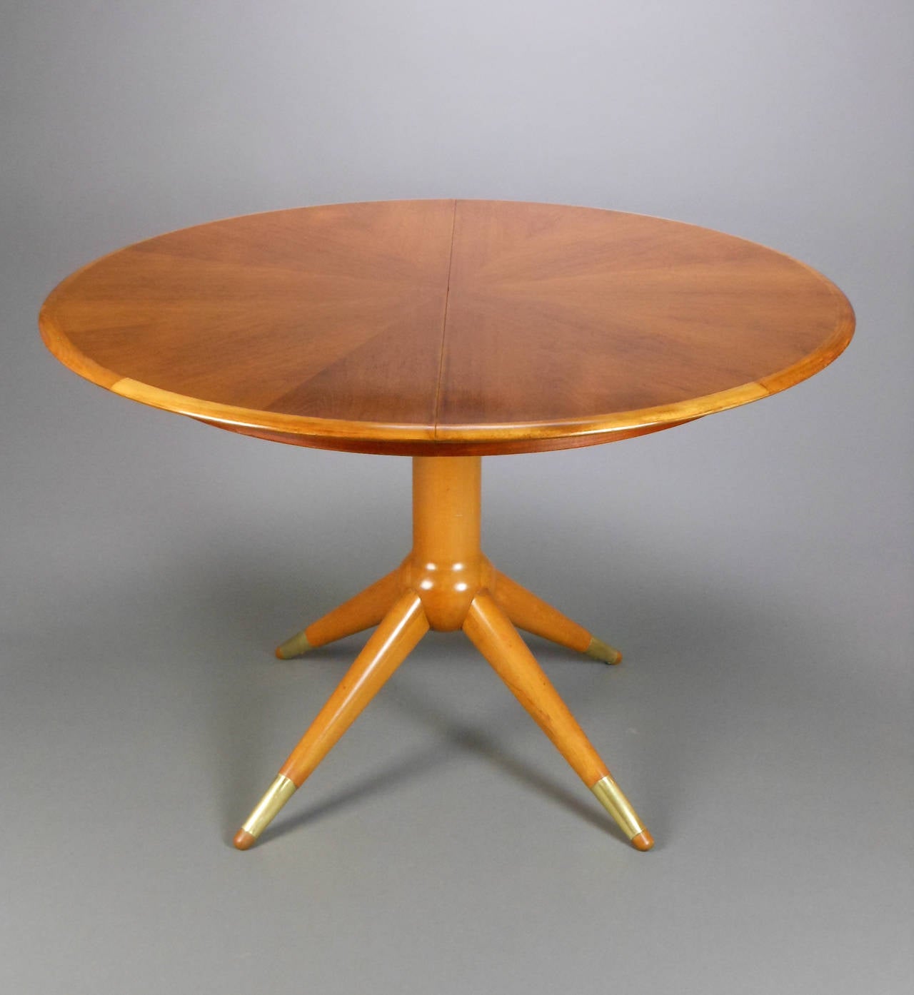 The circular top extending to an oval with all three leaves, the center sputnik pedestal with sphere above four tapering legs ending in sabots. Table extends to 98.75