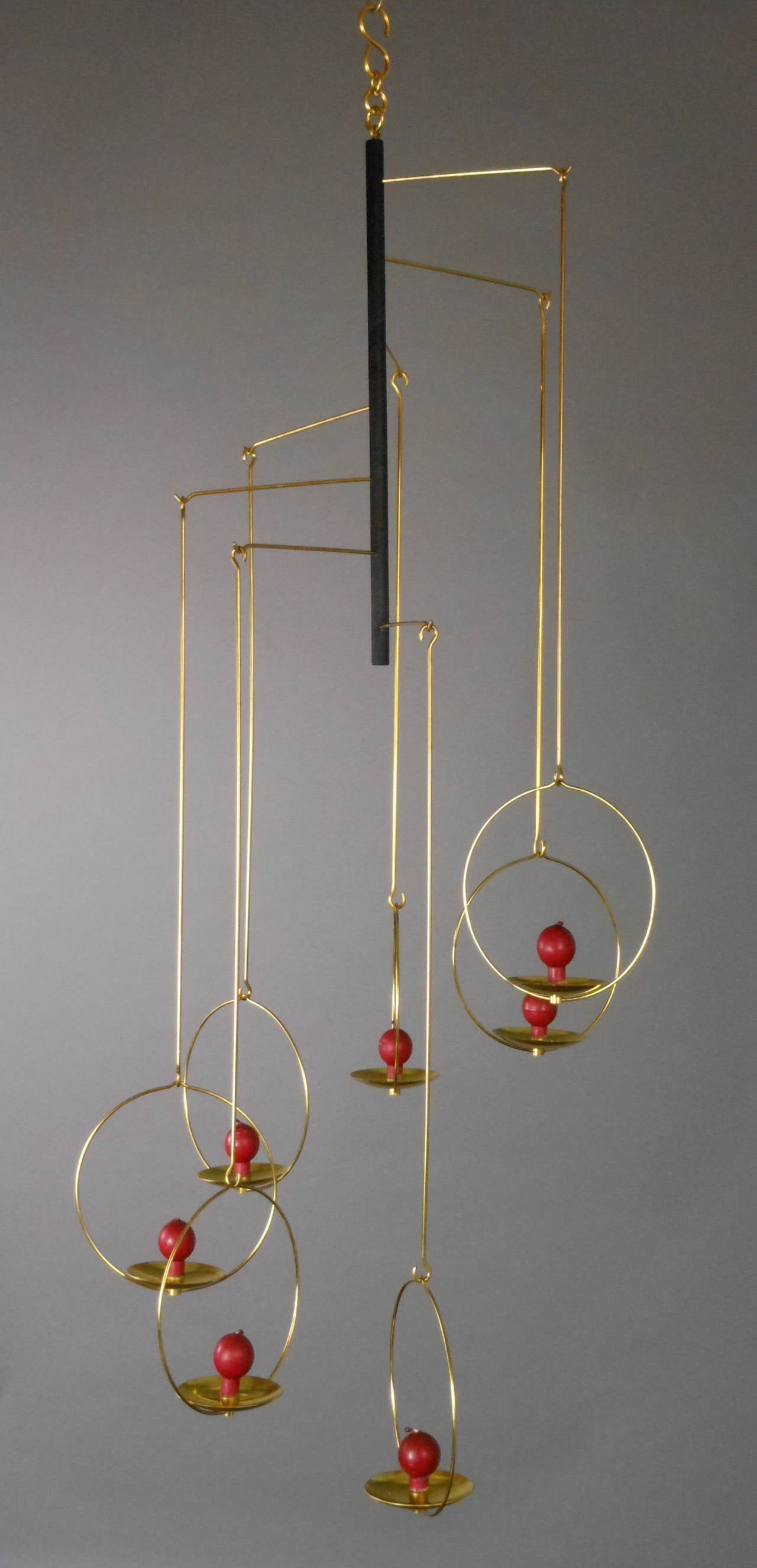 The Finnish candle mobile's centre stem issues seven arms, each hung with a rod and circle holding a candle. Each candleholder plate is stamped on base: AARIKA FINLAND