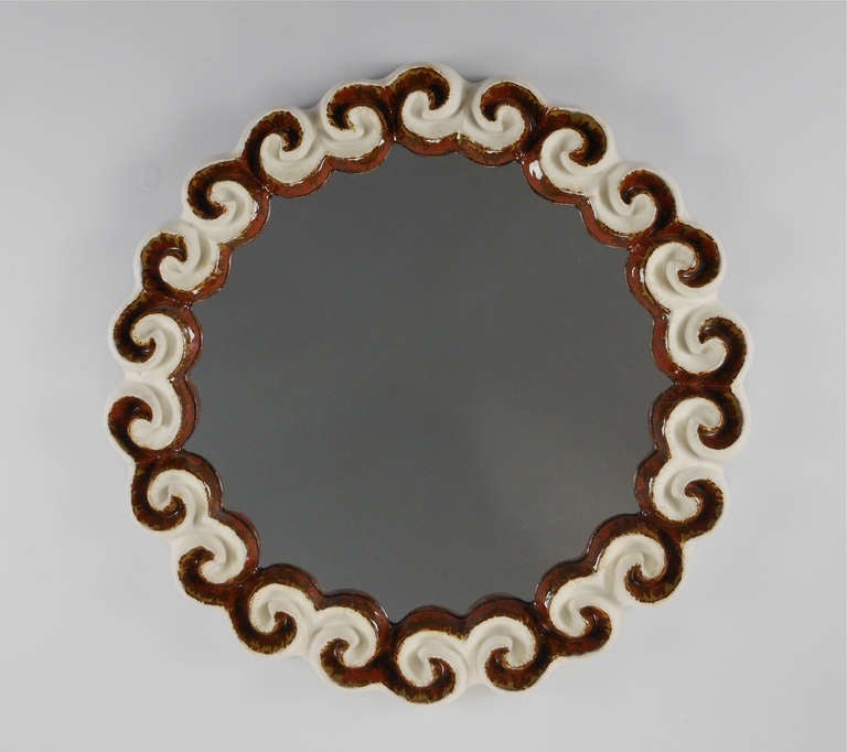 The circular mirror plate sits within the brown and white molded cloud border.