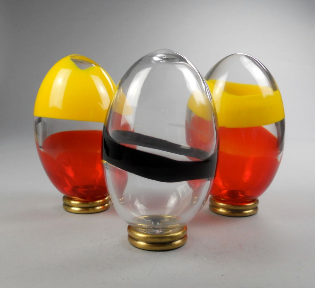 Two ovals of red, yellow, and clear glass, the other of black and clear glass.