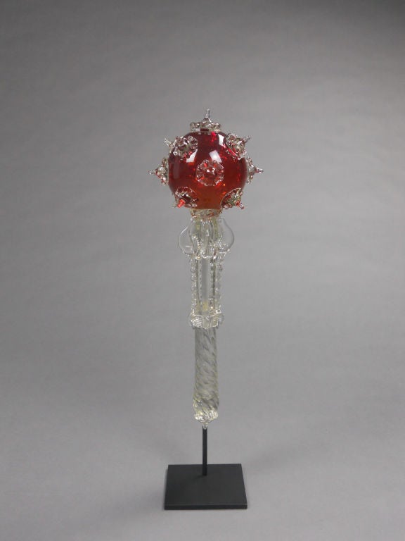 The ruby red orb is studded with spiked rosettes and fused to the shaft with a wave-molded and flanged collar. The beaded and spiral standard ends with a conforming rosette. This unusual Italian sceptre comes with a display stand made especially for