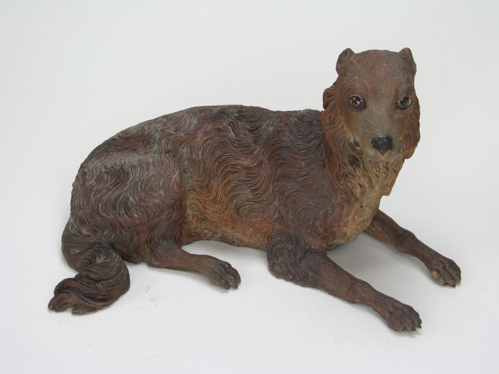 The beautifully modeled seated dog has a finely incised coat and glass eyes.