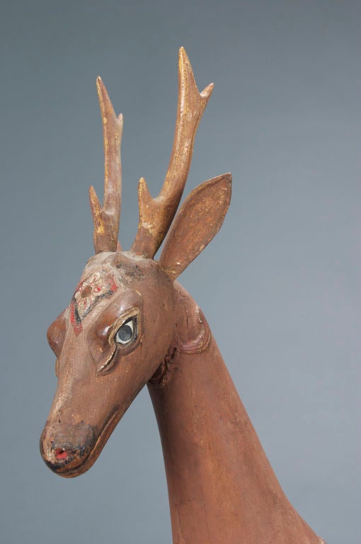 The expressively carved stag is adorned with jewels, collar, and saddle, seated on a rectangular base.