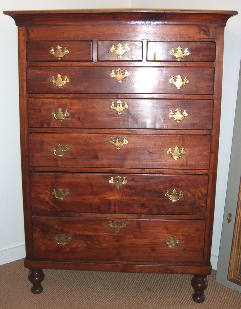 An 8 drawer English Mahogany chest with Solid Brass hardware standing on turned legs.
