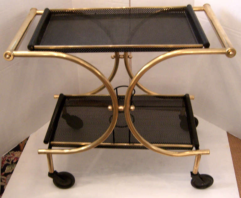 A stunning bar or serving cart by Mathieu Matégot. The cart frame is tubular satin finish brass, and the removable trays are black perforated sheet metal (rigitulle).