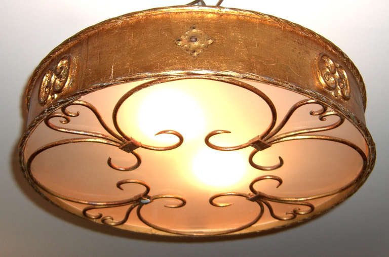 A lovely circular semi-flush mount fixture with frosted glass and gilt iron decorative elements. All wiring is new, and a plate has been added for proper installation.