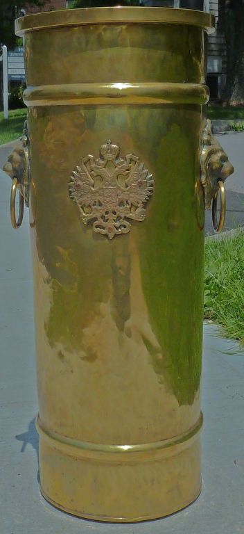 Porte-parapluie de forme cylindrique en laiton martelé avec poignées en forme de têtes de lions et une plaque en laiton représentant un aigle impérial russe, tous deux attachés avec des clous en cuivre