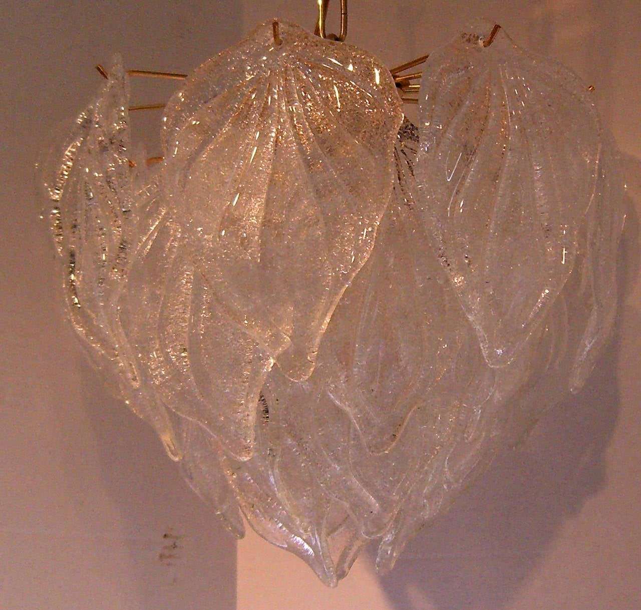 A four-light chandelier with layers of leaf form hanging glass.