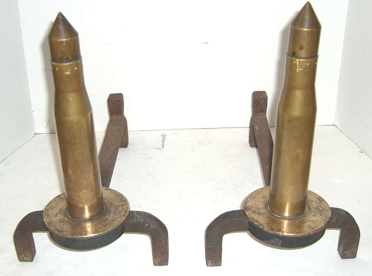 1940s brass ammunition mounted on wrought iron to serve as unique fireplace andirons.