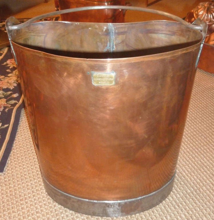 Produced in Beaune France.  Nicely shaped copper bucket with a steel base and iron handle.  Ring in the back allows for wall hanging.