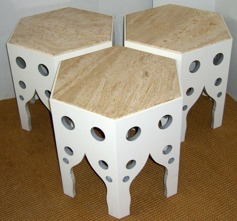 A set of three, six-sided honeycomb tables with a modern Moroccan design. All have a white painted solid wood base and an inset stone top. Easily moved for occasional side tables, or left together as a cocktail table.