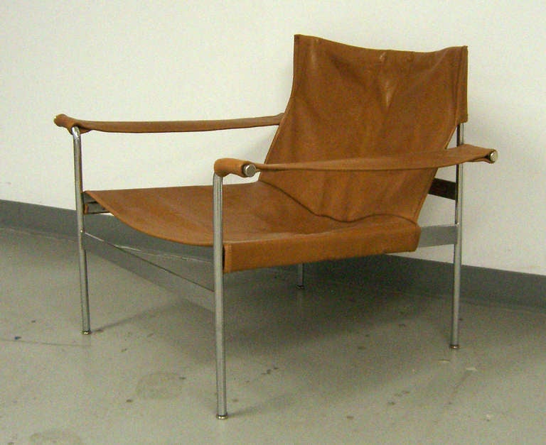 This comfortable lounge chair has a chrome plated metal frame, and a brown leather sling seat. The architect Hans Könecke founded Tecta in 1956 in Germany.
