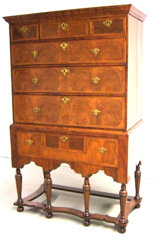 Superb Walnut William & Mary chest on stand with oyster veneer. Six drawers within the chest, and one within the stand. Original Brass hardware.