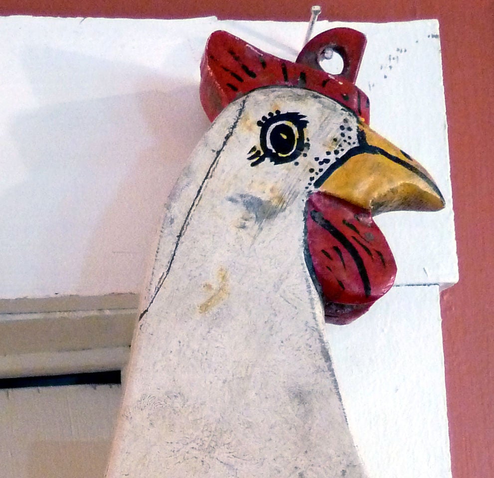 whimsical painted wood sign depicting a chicken standing on an oversized egg.  The sign is double sided and can be viewed from both directions.