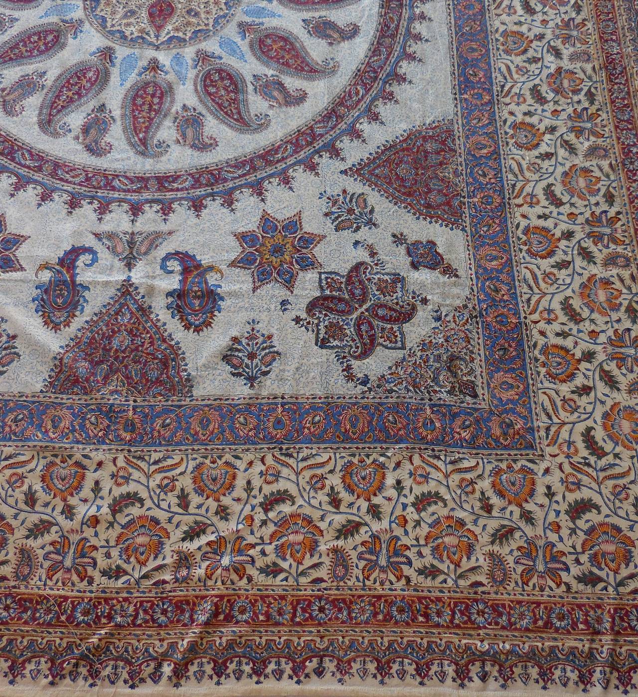 Large old Persian textile from Isfahan Iran, with bothe paisley imprint motifs beautiful round center 
with light blue red salmon colors on cream background.
Few small stains.