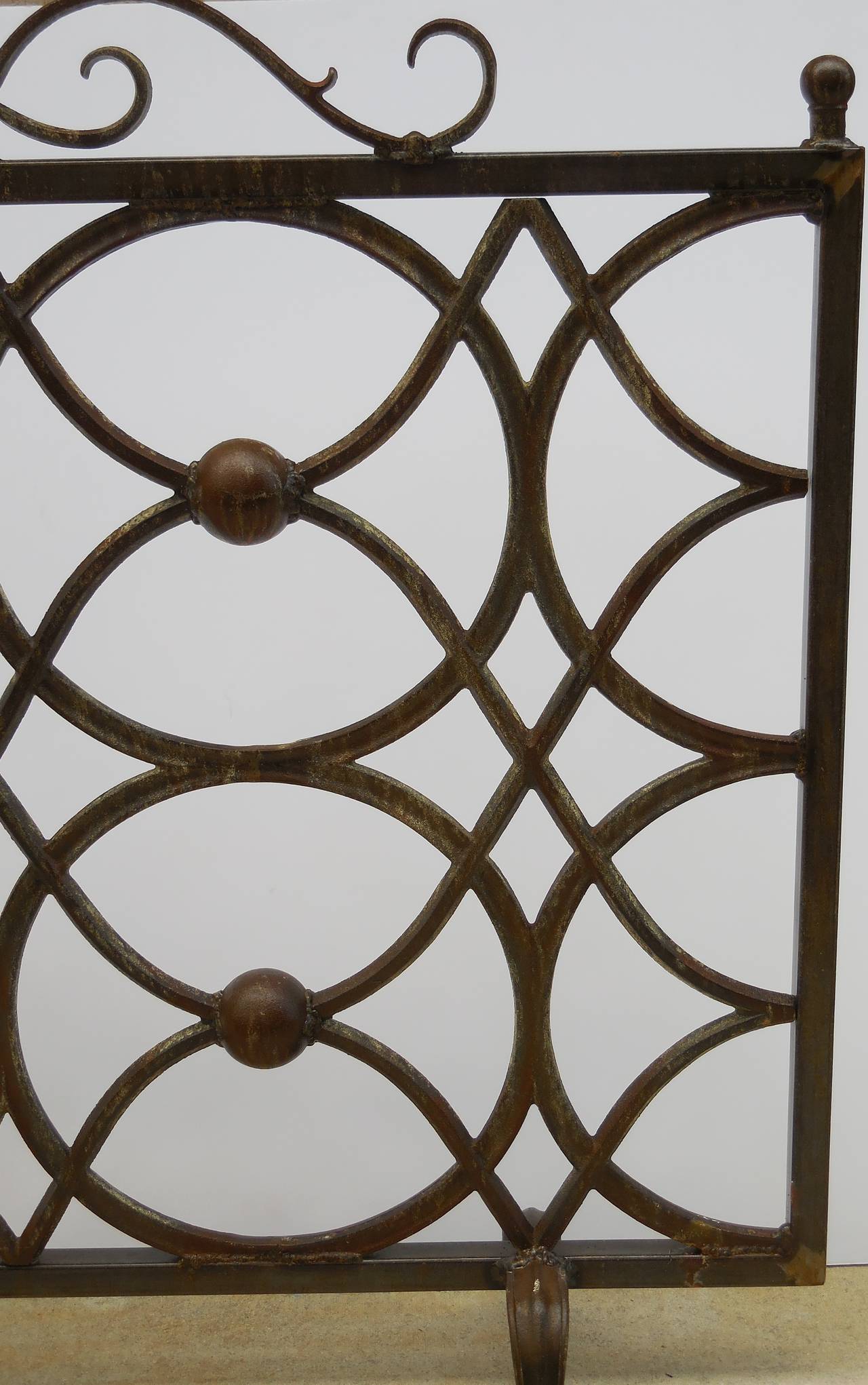 Beautiful cast iron fireplace screen made of four circles held together with scrolling motif and four iron ball in the center.
Great look.
Nice patina.