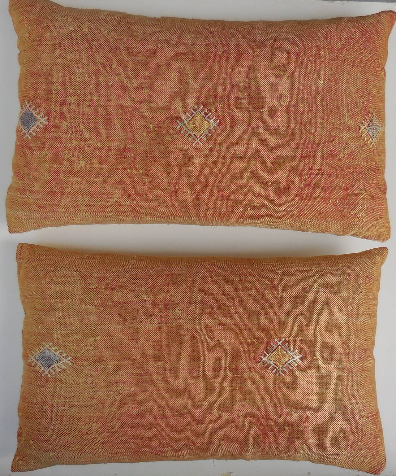 Beautiful pair of pillows made of handwoven rug fragment, with geometric motif
and unusual muted orange color.
New insert. 
Silk backing.