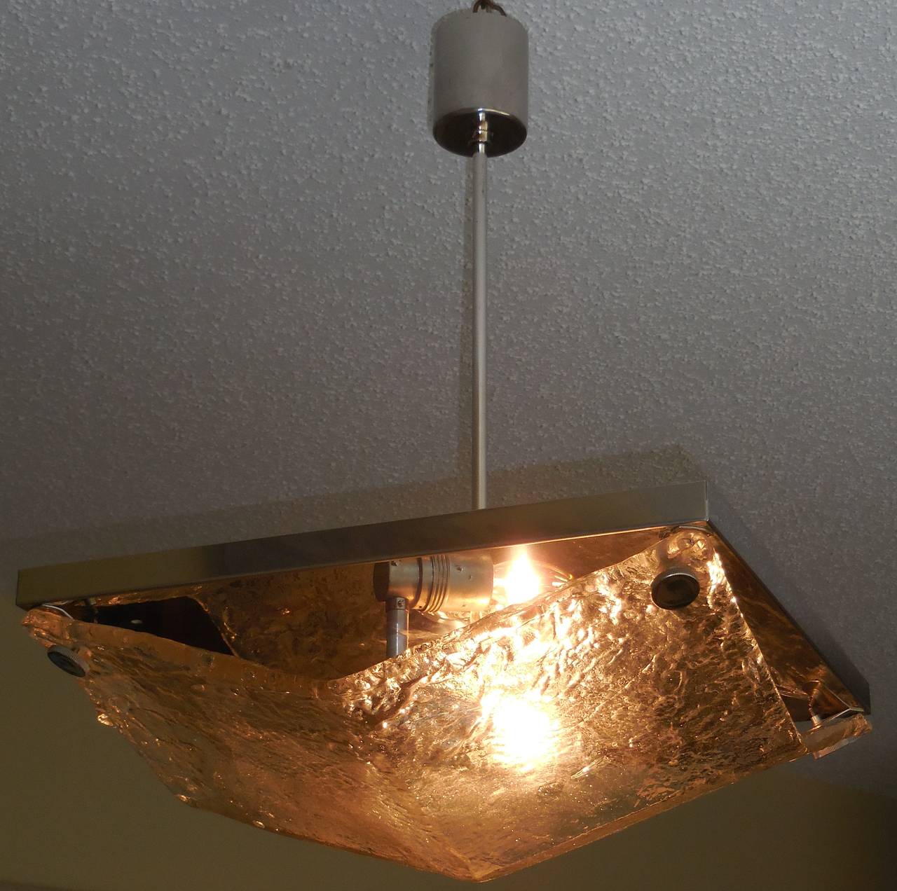 Texture glass chandelier made of one plate large glass folded in four corners.
Polish chrome plate hardware with two 60/ watt light.
Electrified and ready to use.
Could use as a flush mount.
Height could be adjusted.
Light body size without the