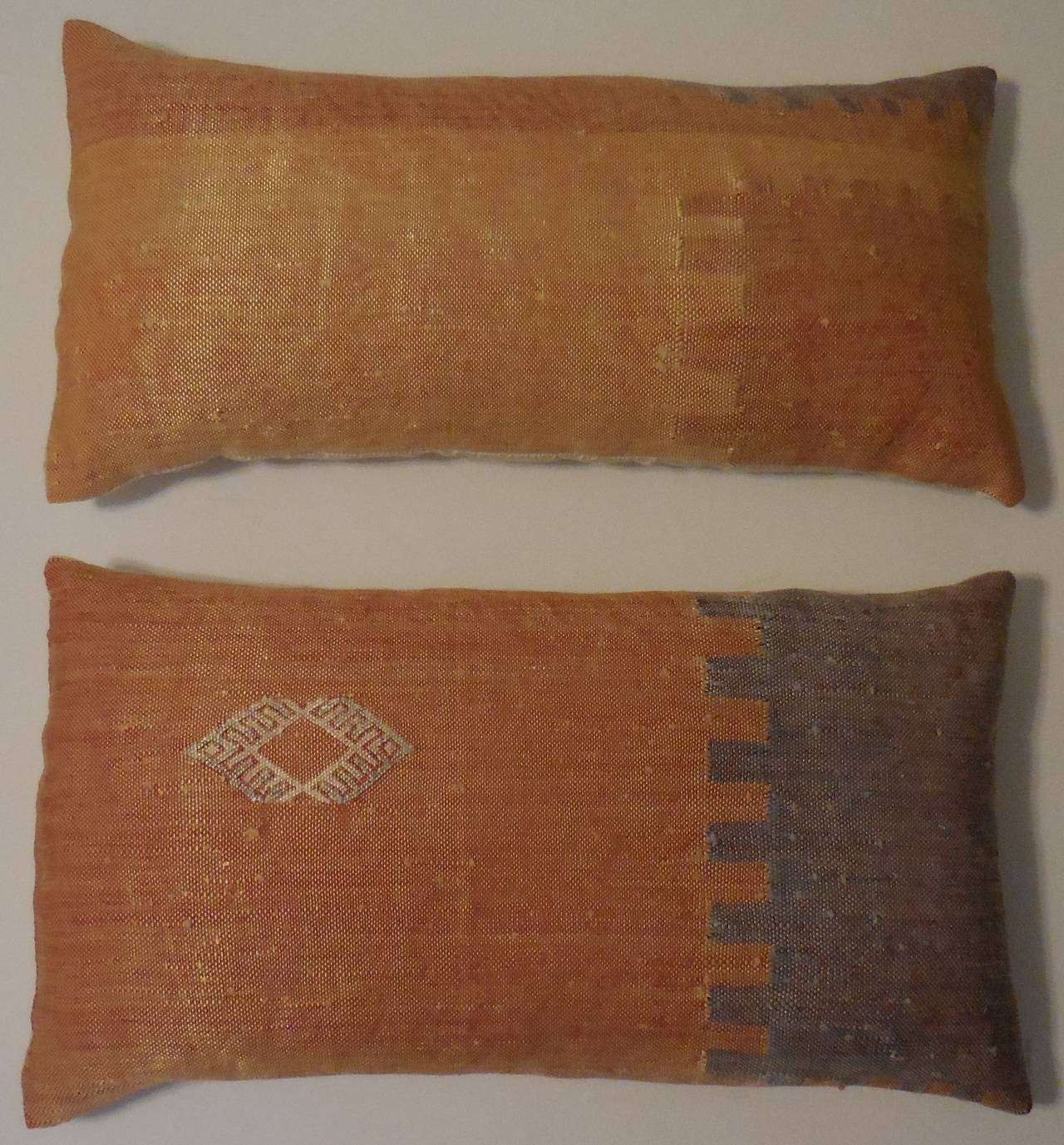 Beautiful pair of pillows, made of handwoven flat-weave silk rug fragment.
Geometric motif with soft color of blue, gray, cream, salmon color on a light. 
Orange background.
Fine silk backing.
Fresh inserts.
Sizes
1. 12