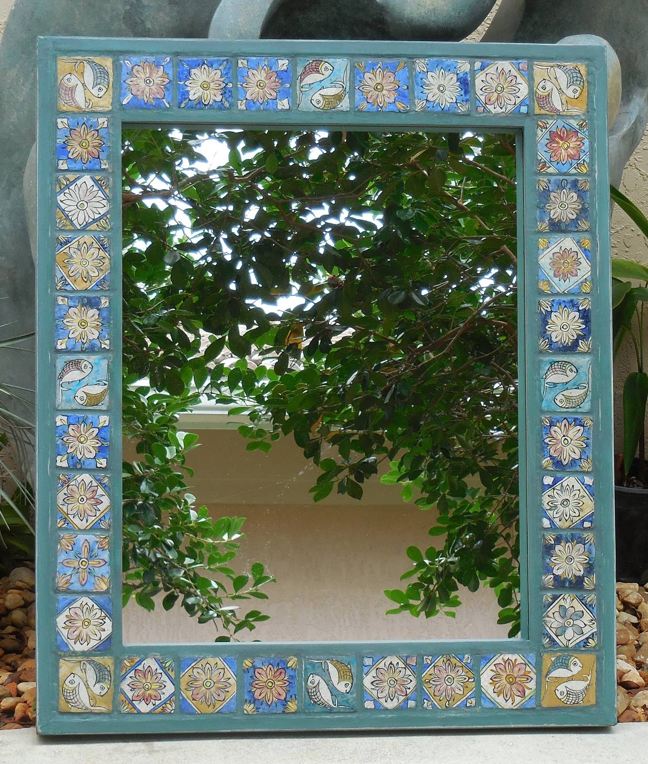 Beautiful mirror made of hand-painted and glass Persian ceramic tiles laid on wood frame, treated with water repellent all around and could stay the elements.
Floral and fish motif tiles.
Could hang horizontal or vertical.
Actual mirror side: