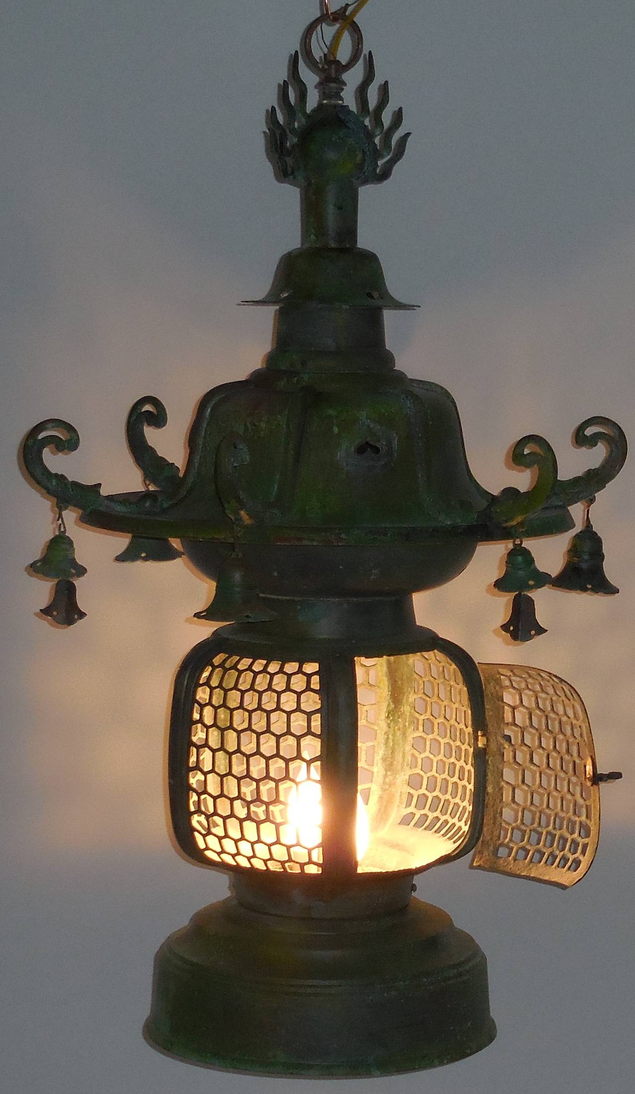 Antique copper hanging lantern, originally was a gas street lantern converted into hanging lantern. Wire with new brass steam with two 60/watt lights.
The lantern is decorated with six dragon heads and six bells hanging over them.
Some floral and
