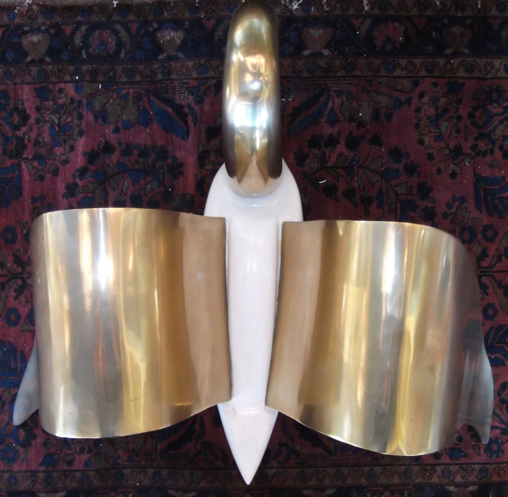 Solid brass swan with beautiful extended wings to the sides the head is looking 
Downward and use with the wings as a base for coffee table .
Could also be used as sculpture for decoration.
The brass body is white satin painted .