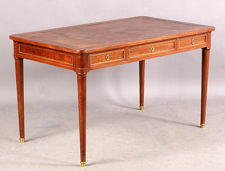 Newly restored with black leather
French Louis XVI style  Jansen desk having an inset leather top over three bronze trimmed drawers.  Turned legs with bronze sabots.