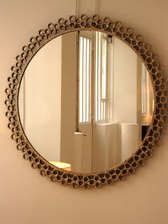 A Round Mirror/ Sculpture with a beautifully hand-crafted nickeled Bronze Frame made of multiple welded pieces.  A unique welding and patina technique reminiscent  of  sculptures by  Arman who was a mentor to this artist.