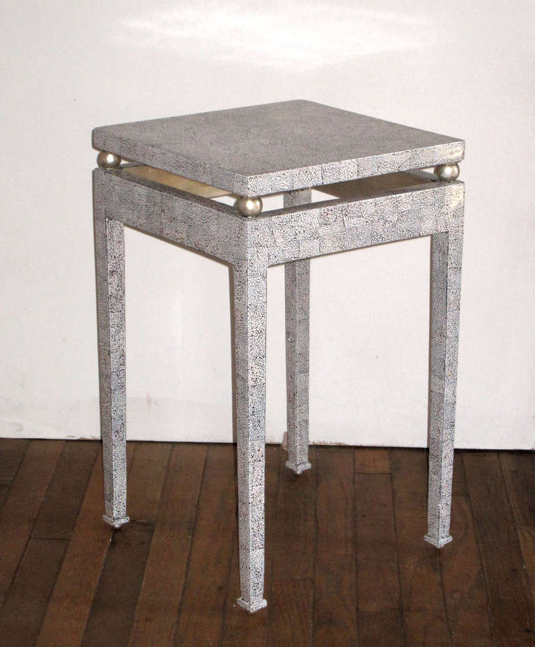 A beautifully crafted pair of contemporary  side tables in eggshell and lacquer..
The form is reminiscent of the work of Marcel Coard c. 1925
The table sits on 4 silver leafed balls below a sabot. The top is raised on similar  silver leafed balls.