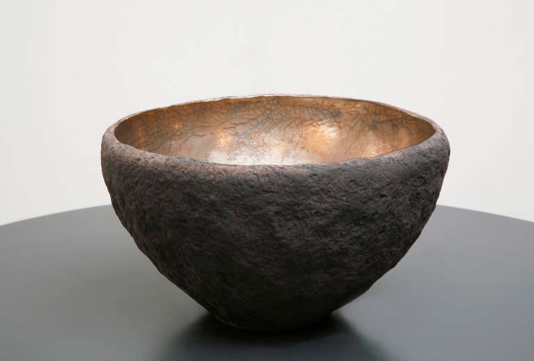 A unique vessel with  platinum inside made by artist Cristina Salusti.

Beginning with a ball of clay, she pinches it into vessels and textures them with stone fragments. After multiple firing it was finally lustered with 22 Carat gold over
