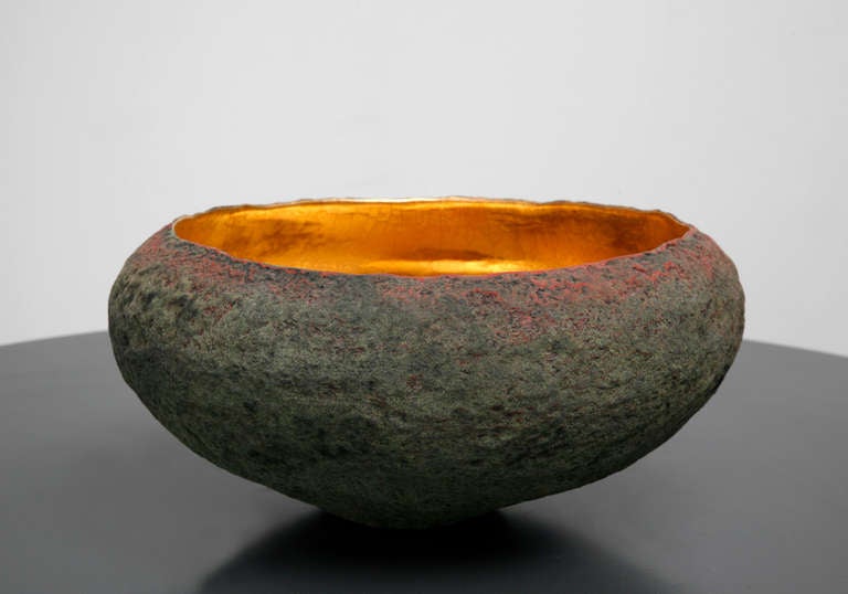 A medium round vessel with 22 k inside made by artist Cristina Salusti
Beginning with a ball of clay, she pinches it into vessels and textures them with stone fragments. After multiple firing it was finally lustered with 22K gold . Its