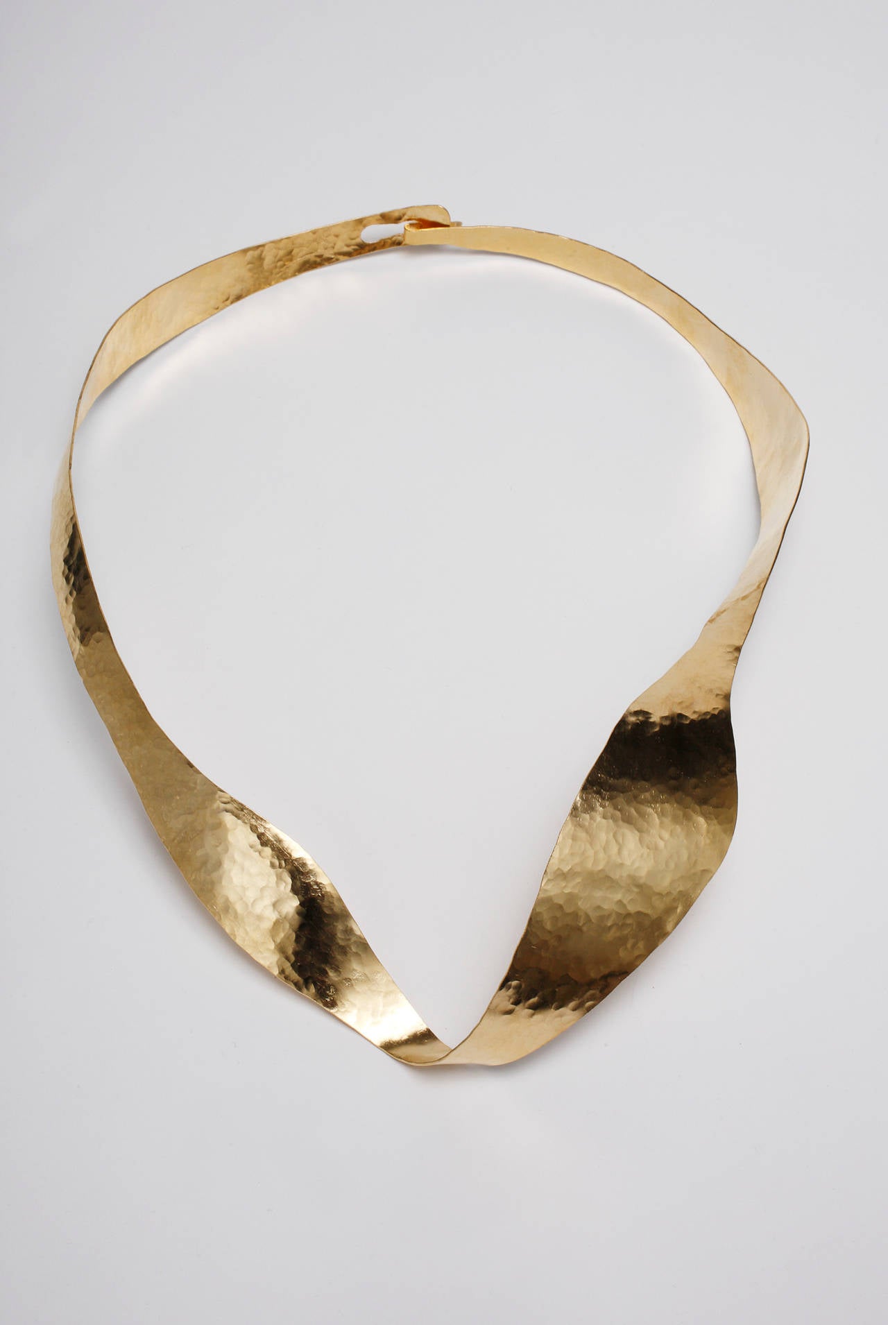This splendid piece of jewelry like all of Jarrige's work perfectly captures movement. It undulates with serenity and beauty.

This necklace is hand-sculpted and hand-hammered in brass, gold plated with 18-karat gold (three