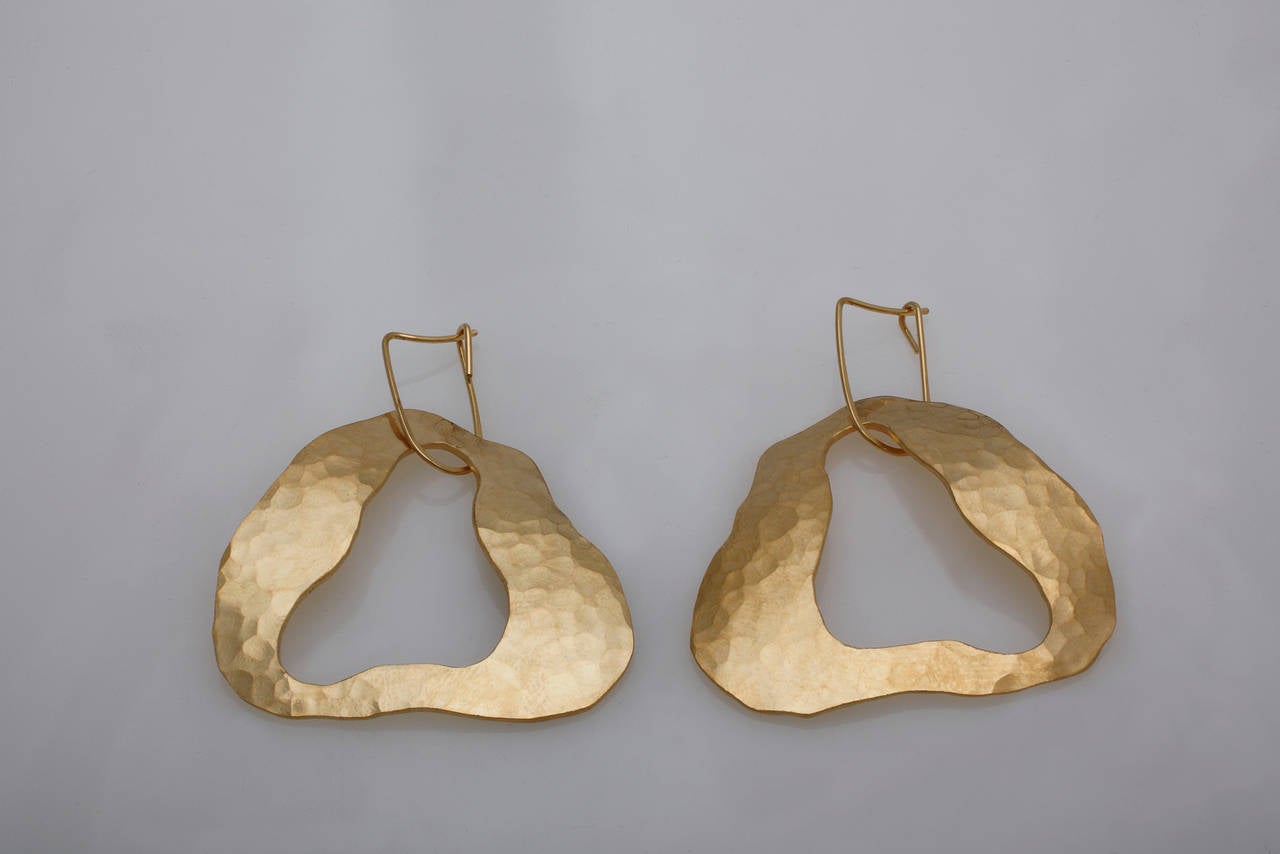 Tragbares Kunstwerk von Jacques Jarrige. Diese Ohrringe sind handgeformt und gehämmert aus Sterlingsilber und vergoldet mit 18 Karat, 5 Mikron.
Auch in Sterlingsilber erhältlich.

Diese tragbare Skulptur ist eine unverkennbare Anlehnung an