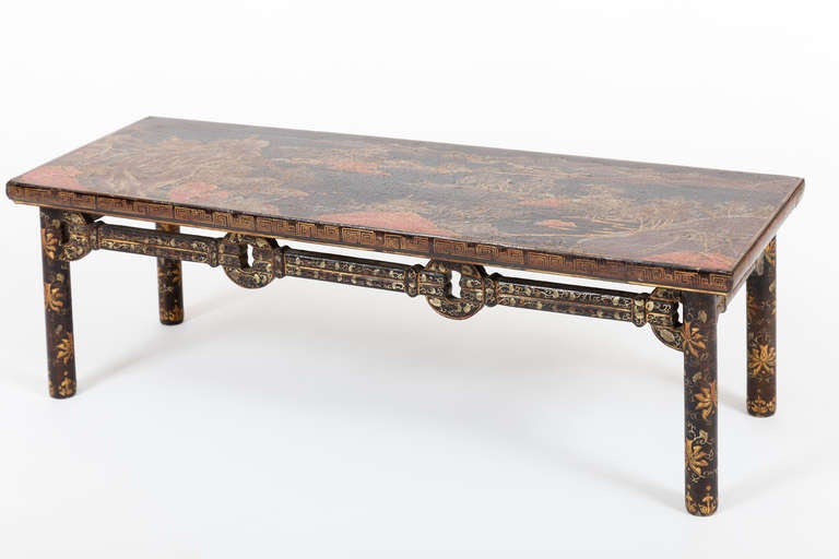 This fine early 19th century Chinese Qing Dynasty low table has a finely detailed mountainous landscape on its rectangular top, executed in lacquer in a black ground. The apron and legs have geometric and foliate motifs in parcel gilding on a black